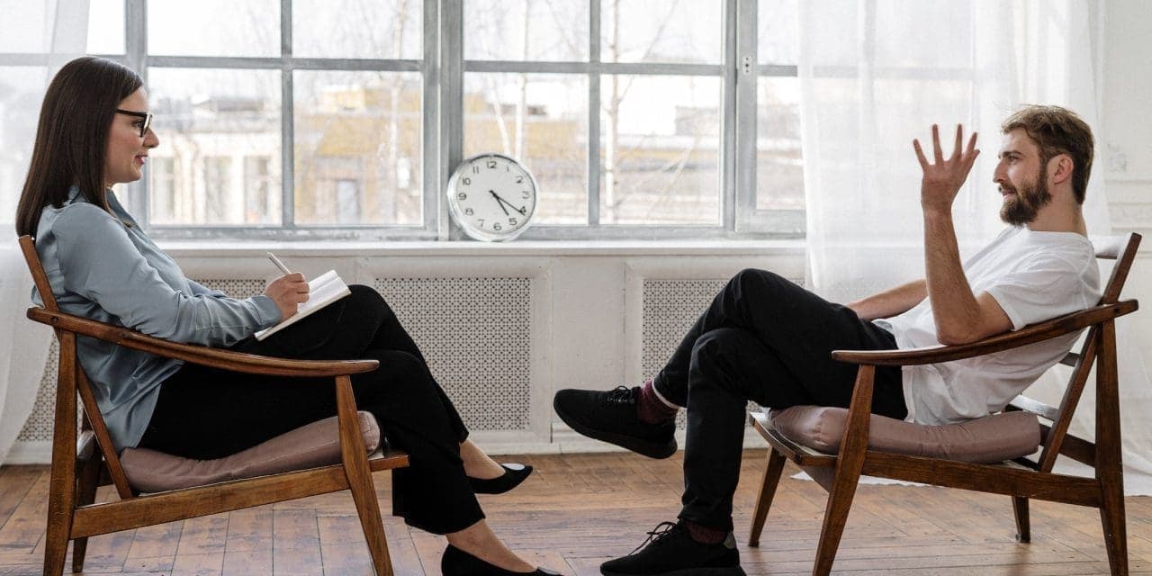 two persons sitting across each other, looks like consulting